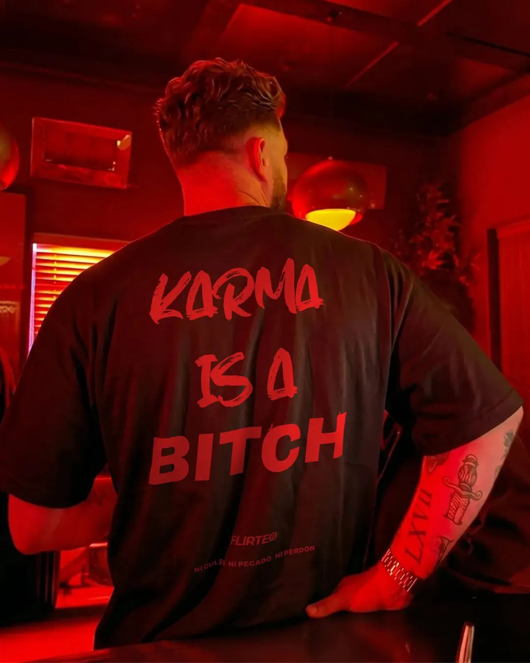 Camiseta oversize negra KARMA IS A BITCH de FLIRTEO. Diseño exclusivo, 100% algodón 240gr con actitud underground de discoteca. Tallas S-XL.